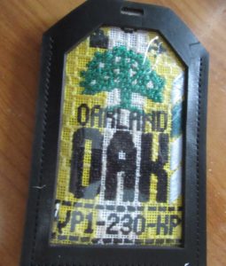 finished needlepoint Oakland luggage tag