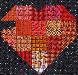orange sapphire heart stitches for needlepoint sampler on black metallic canvas, designed by Janet Perry