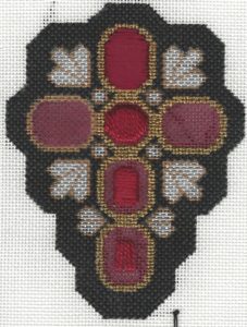 cross showingf stages of needlepoint padding