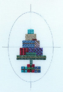 oval needlepoint ornament with design centered